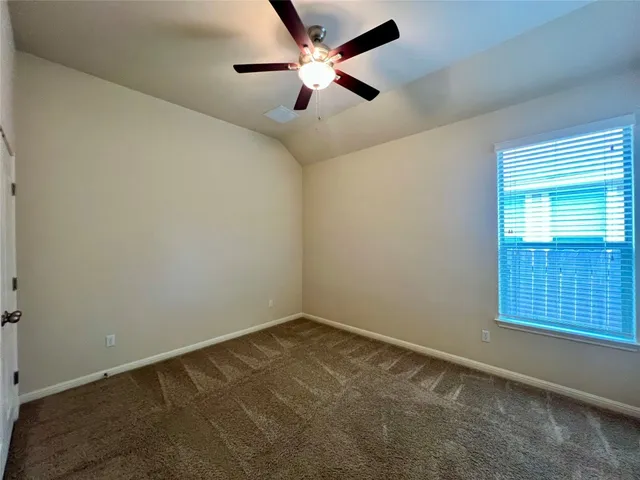 an empty room with a window and a fan