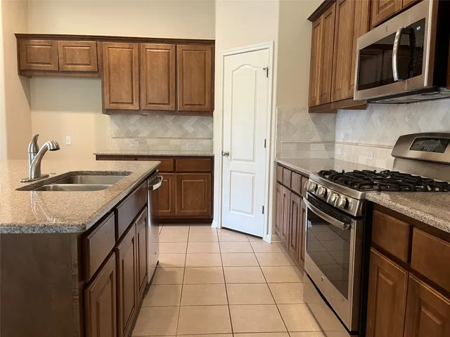 a kitchen with stainless steel appliances granite countertop a sink and a stove