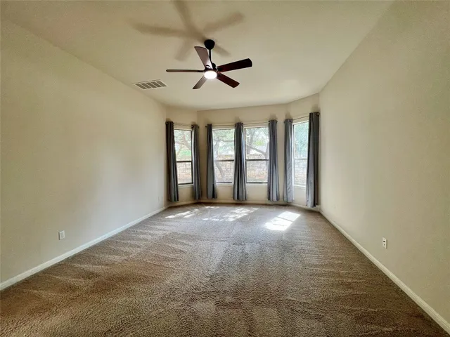 an empty room with fireplace and windows