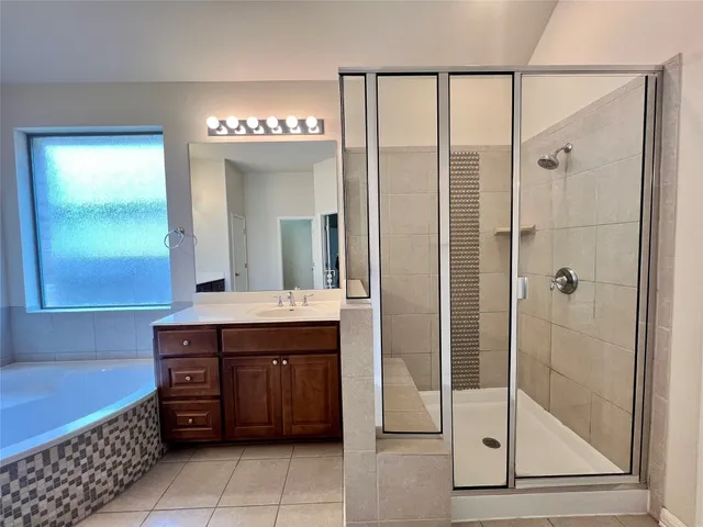 a bathroom with a tub a sink and a large mirror