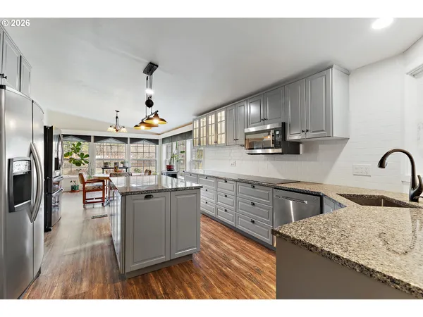 a kitchen with stainless steel appliances granite countertop a sink dishwasher stove refrigerator and microwave
