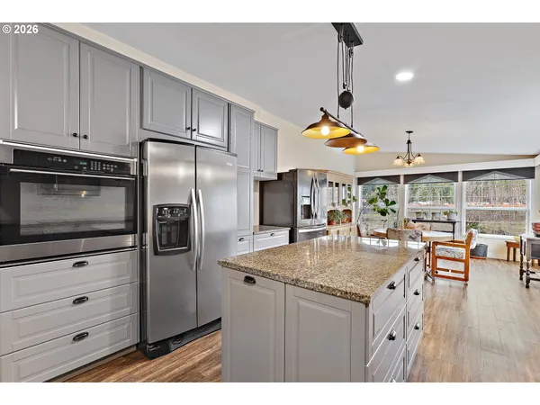 a kitchen with stainless steel appliances granite countertop a sink a stove and refrigerator