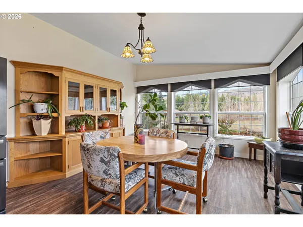 a dining room with furniture a large window and wooden floor