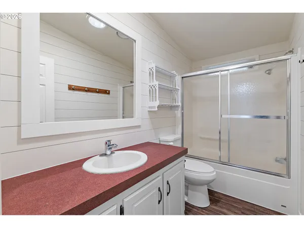 a bathroom with a sink toilet a mirror and shower