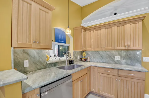 a kitchen with granite countertop a sink a stove and cabinets
