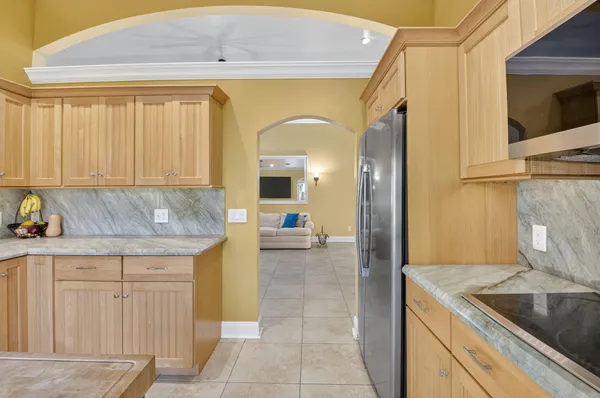 a kitchen with stainless steel appliances kitchen island granite countertop a refrigerator a stove and a sink