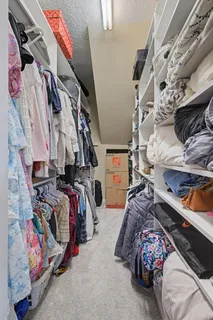 a view of walk in closet with clothes and shoes