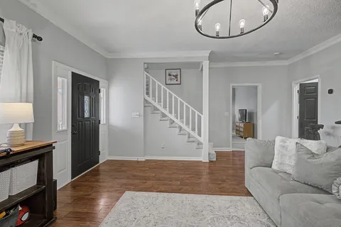 a living room with furniture and a chandelier
