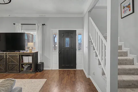 a view of a livingroom with wooden floor and furniture