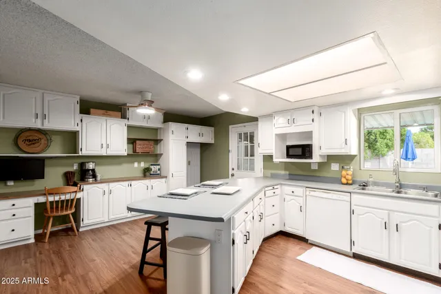 a kitchen with a sink cabinets and wooden floor