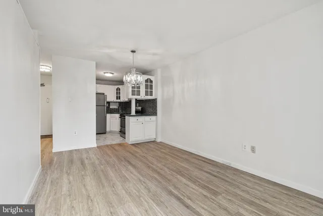 a view of a kitchen with wooden floor and electronic appliances