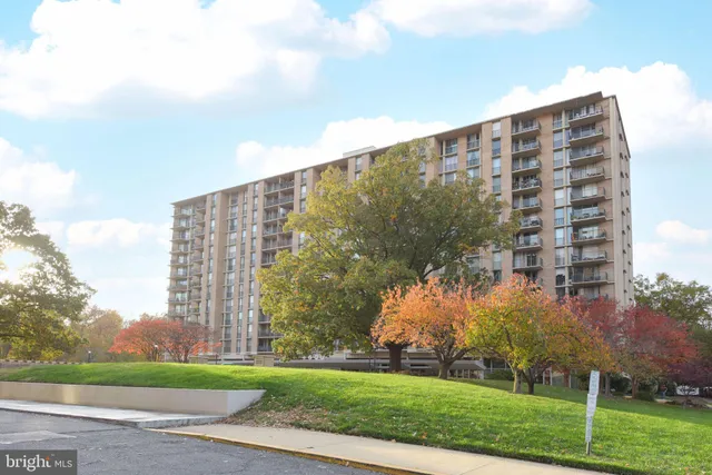 a view of a tall building next to a yard