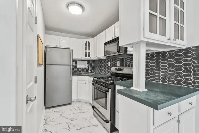 a kitchen with stainless steel appliances granite countertop a refrigerator a stove and a sink