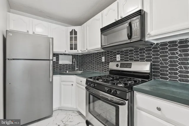 a kitchen with stainless steel appliances granite countertop a stove a refrigerator and a microwave