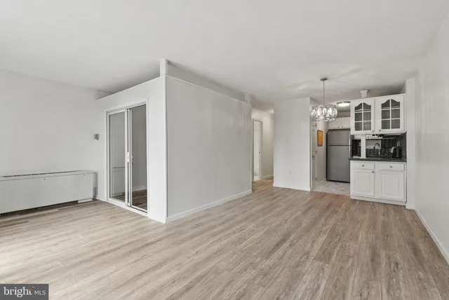 a view of a kitchen with wooden floor and electronic appliances
