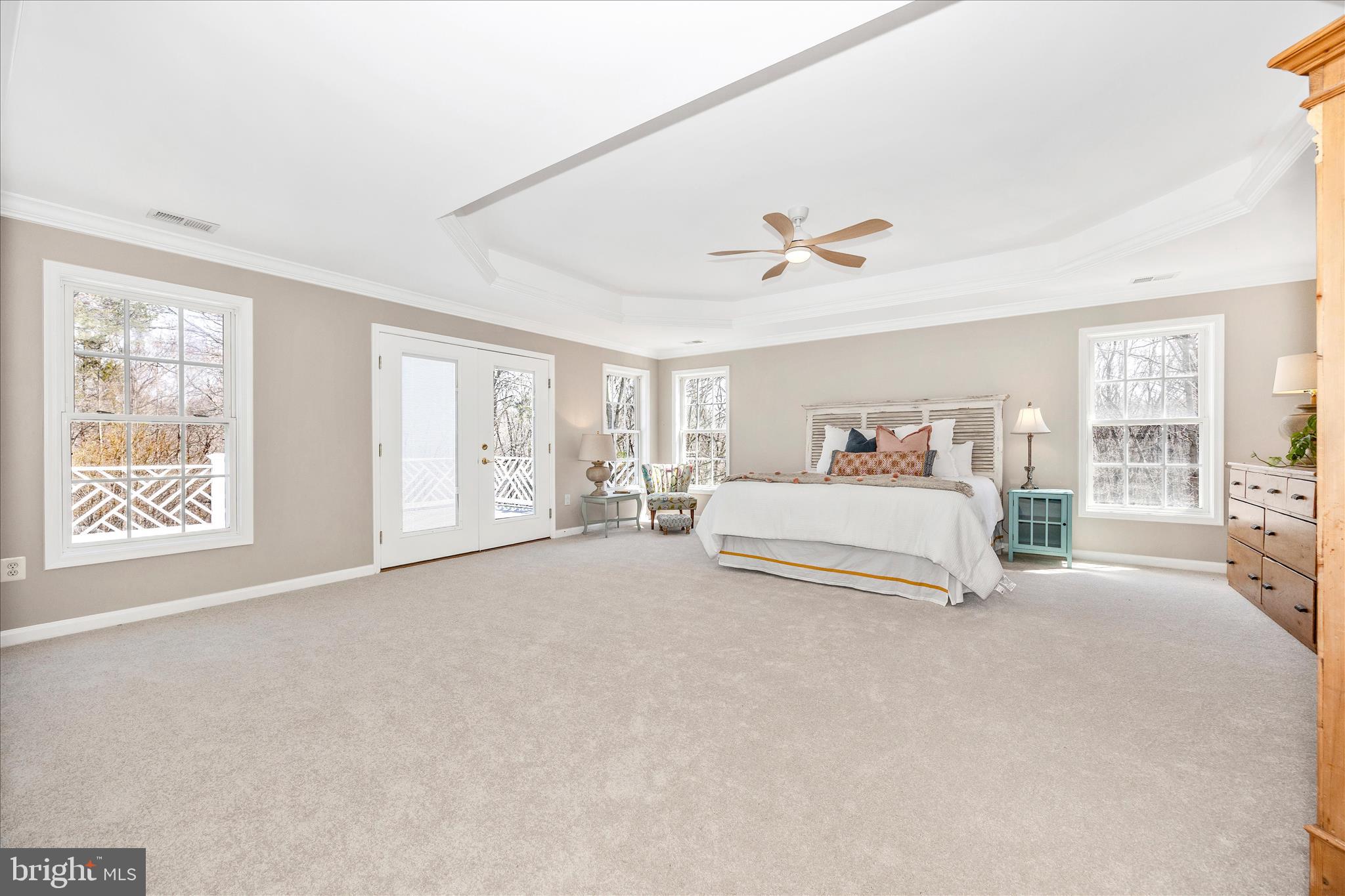 6243 Woodville Road Mount Airy, MD 21771 - Photo 20 of 50 a spacious bedroom with a large bed a chandelier and windows