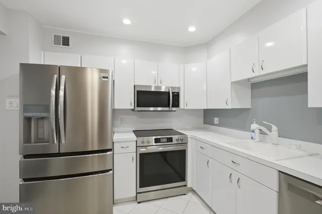 a kitchen with stainless steel appliances a refrigerator sink and microwave