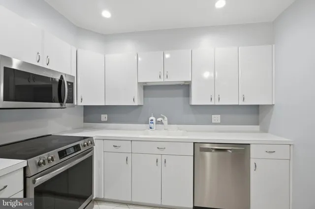 a kitchen with appliances a sink and cabinets