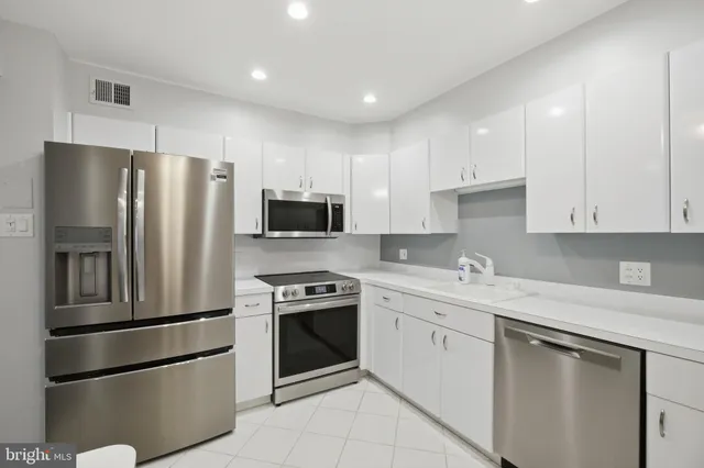 a kitchen with stainless steel appliances granite countertop a refrigerator sink and stove