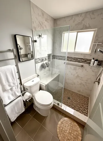 a bathroom with a toilet mirror vanity and window