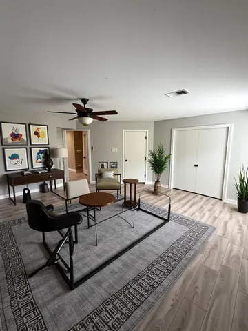 a living room with furniture and a wooden floor