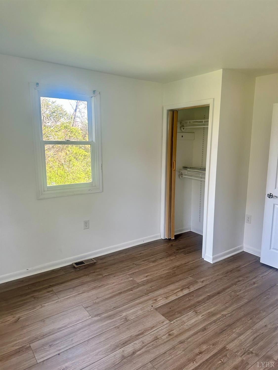 476 Kenmore Road Amherst, VA 24521 - Photo 11 of 32 a view of an empty room with wooden floor and a window