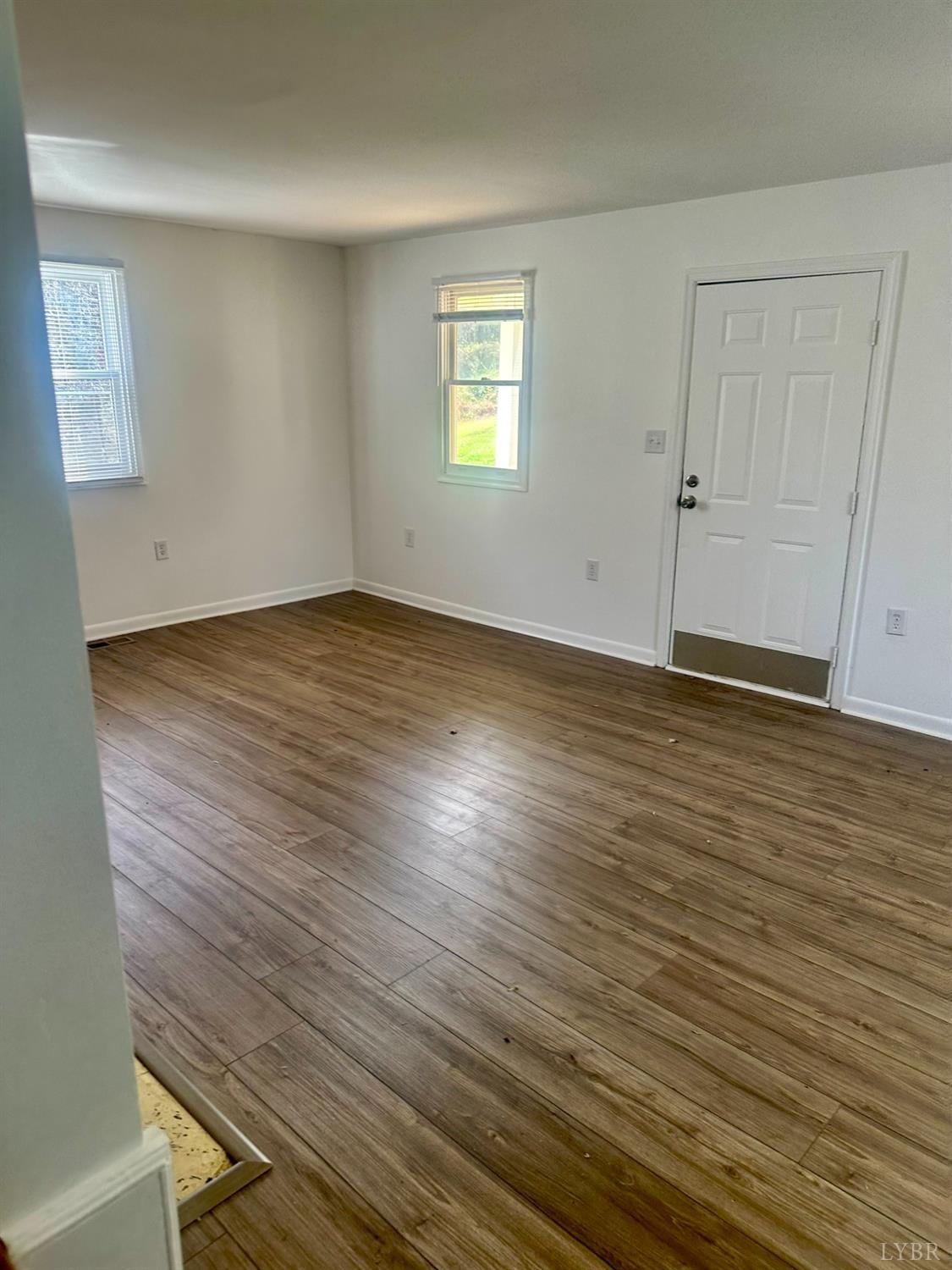 476 Kenmore Road Amherst, VA 24521 - Photo 5 of 32 an empty room with wooden floor and windows