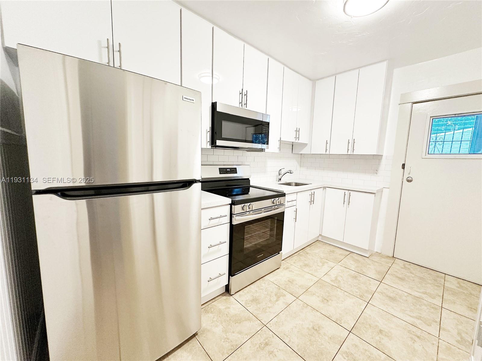2153 Southwest 14th Terrace, Unit 1 Miami, FL 33145 - Photo 3 of 17 a kitchen with white cabinets and white appliances