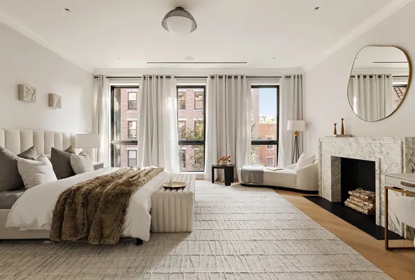 a spacious bedroom with a large bed and a fireplace