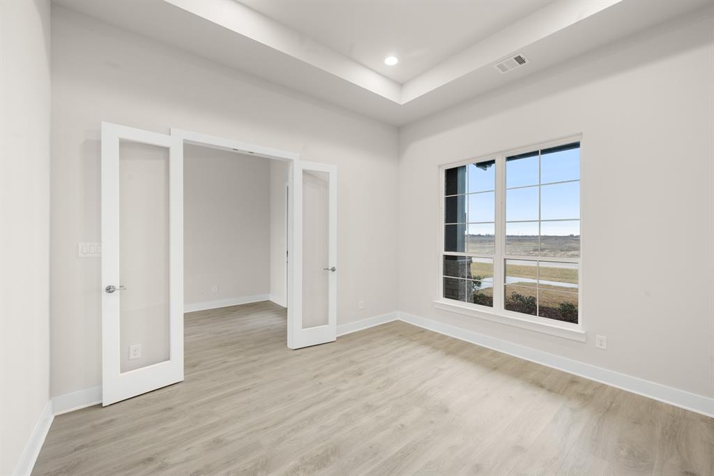 151 Talpin Lane Venus, TX 76084 - Photo 4 of 28 a view of an empty room with wooden floor and a window