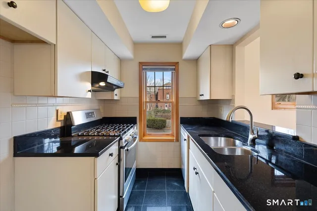 a kitchen with stainless steel appliances a sink stove and cabinets