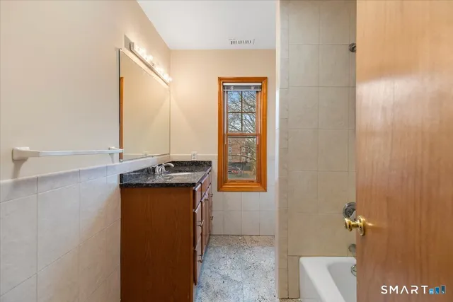 a bathroom with a granite countertop sink a toilet and shower