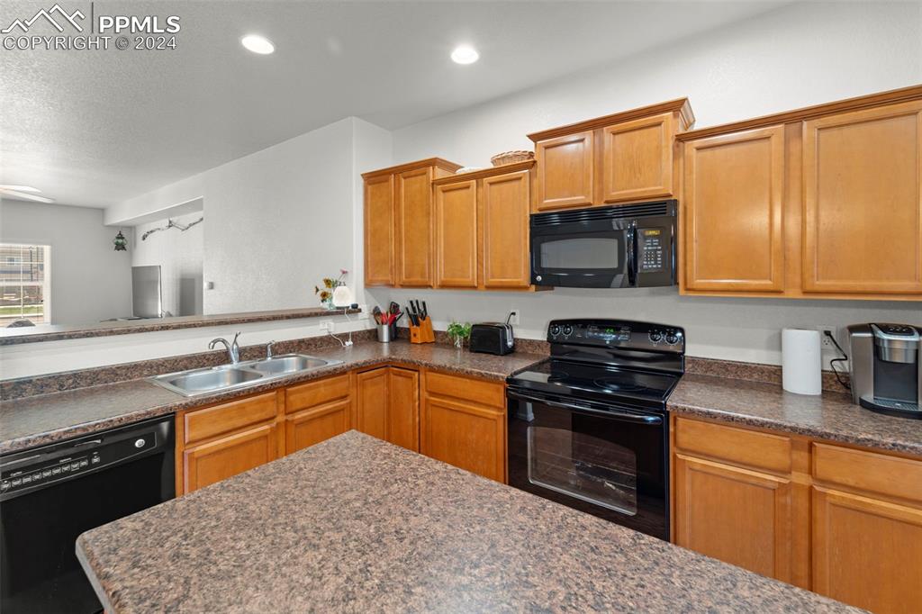 6310 Pilgrimage Road Colorado Springs, CO 80925 - Photo 15 of 31 a kitchen with stainless steel appliances granite countertop a stove sink and cabinets