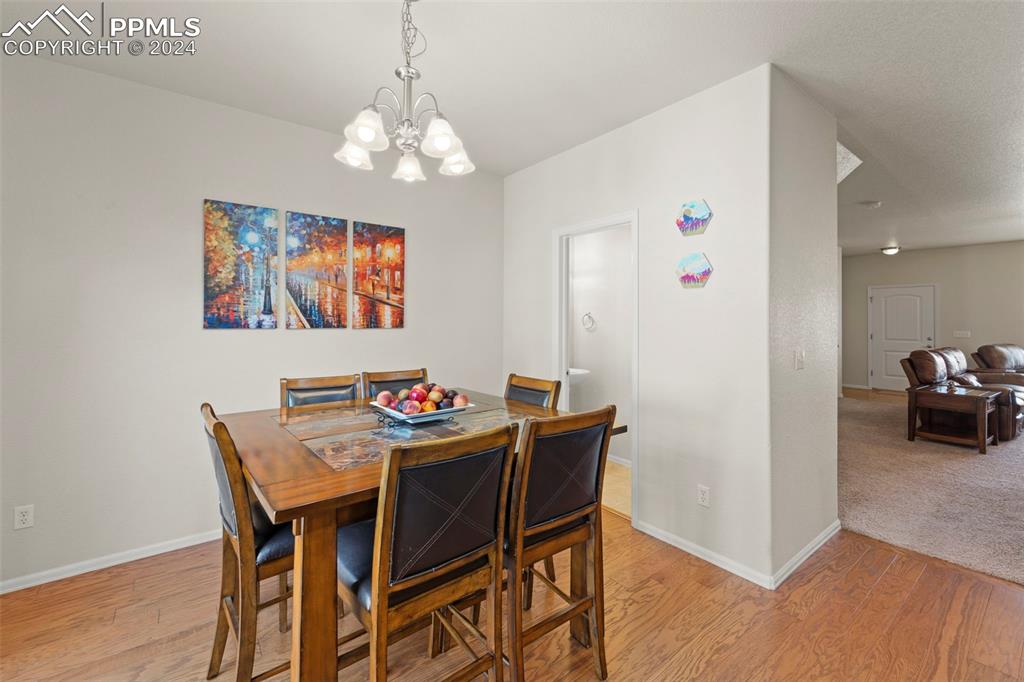 6310 Pilgrimage Road Colorado Springs, CO 80925 - Photo 17 of 31 a view of a dining room with furniture and wooden floor
