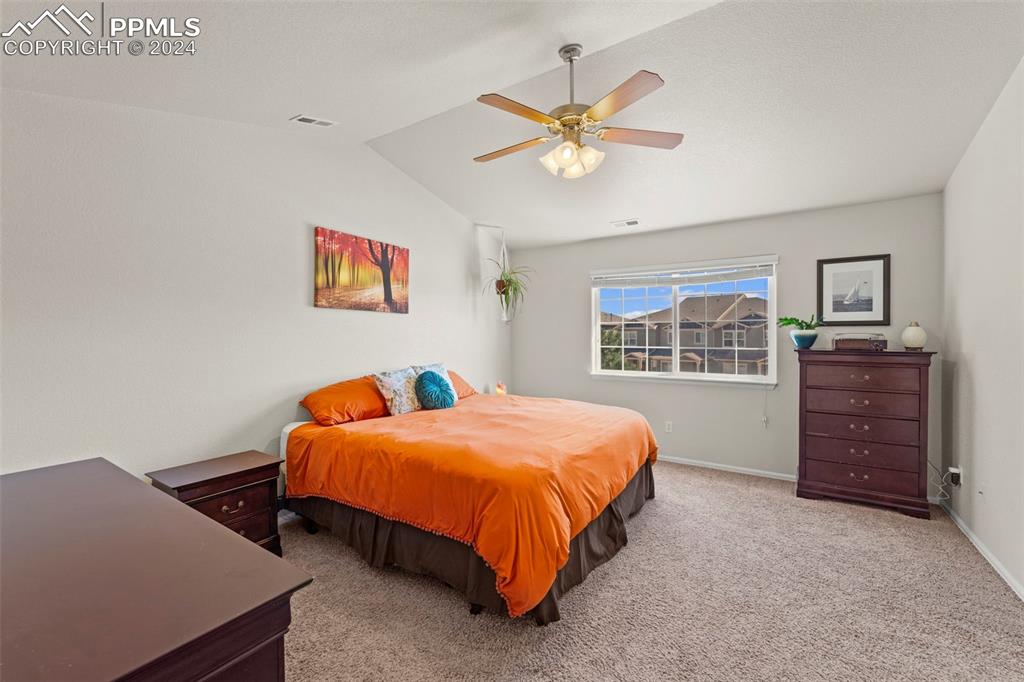 6310 Pilgrimage Road Colorado Springs, CO 80925 - Photo 22 of 31 a bedroom with a bed and a chandelier
