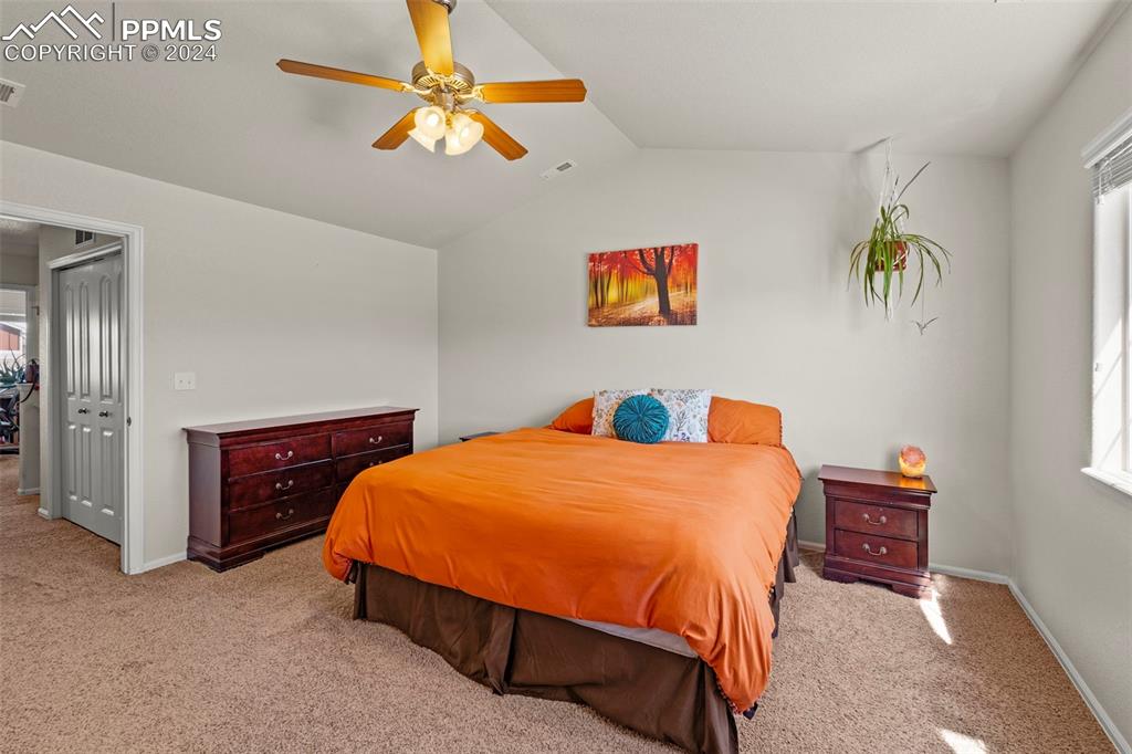 6310 Pilgrimage Road Colorado Springs, CO 80925 - Photo 24 of 31 a bedroom with a bed and a chandelier