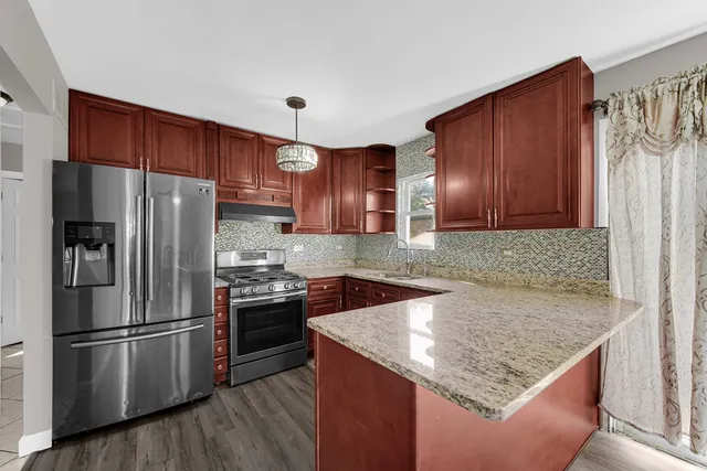 a kitchen with granite countertop wooden cabinets and stainless steel appliances