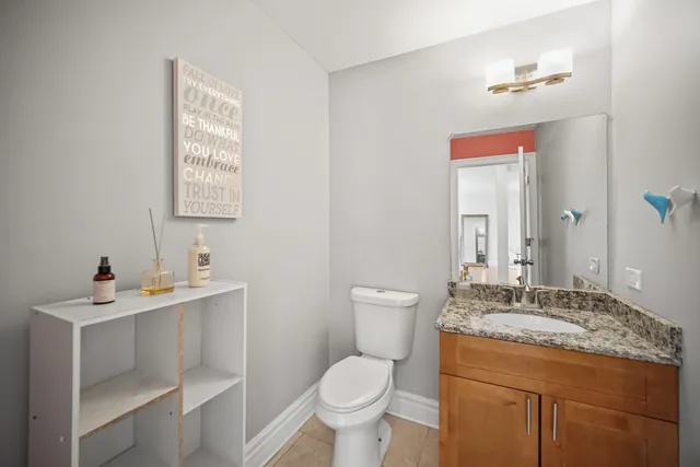 a bathroom with a granite countertop toilet sink and mirror