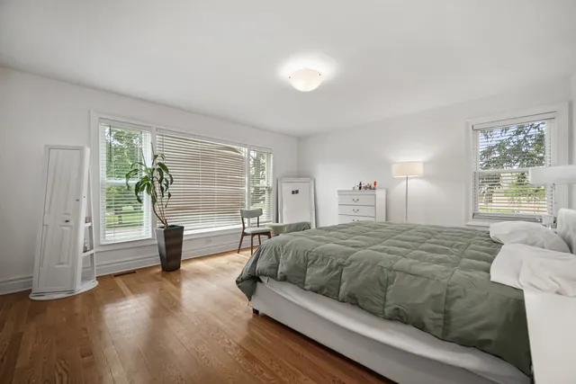 a bedroom with a bed and a large window