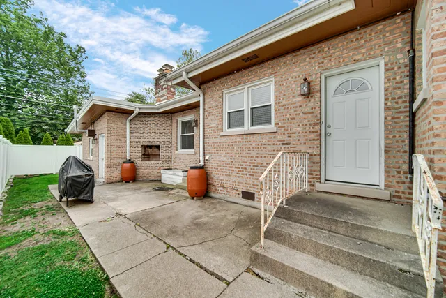 a view of a house with a patio and a yard