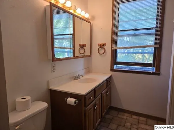 a bathroom with a sink a toilet and a window