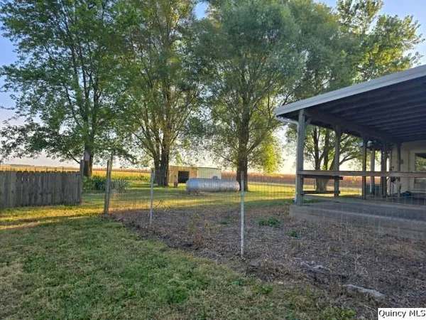 a view of a house with backyard and trees