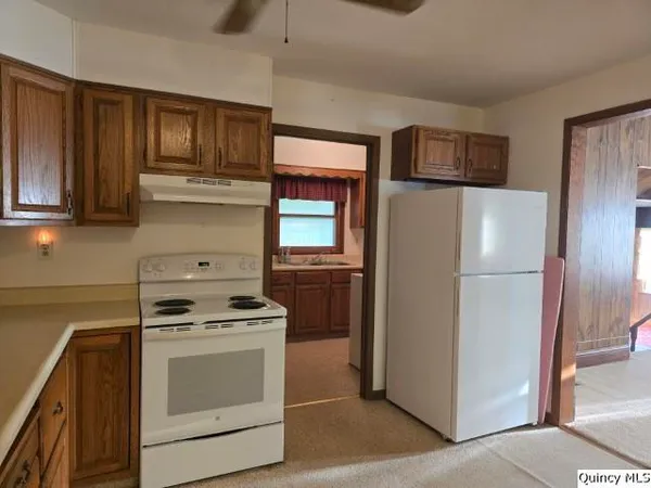 a kitchen with stainless steel appliances granite countertop a refrigerator stove and cabinets