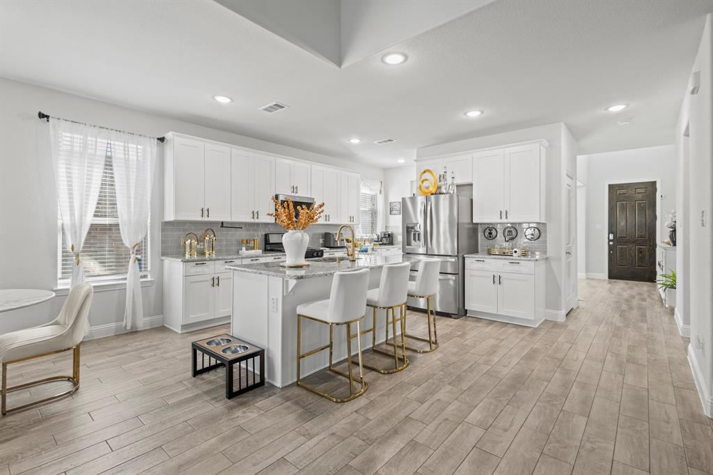 4220 Calla Drive Forney, TX 75126 - Photo 4 of 30 a kitchen with white cabinets and chairs