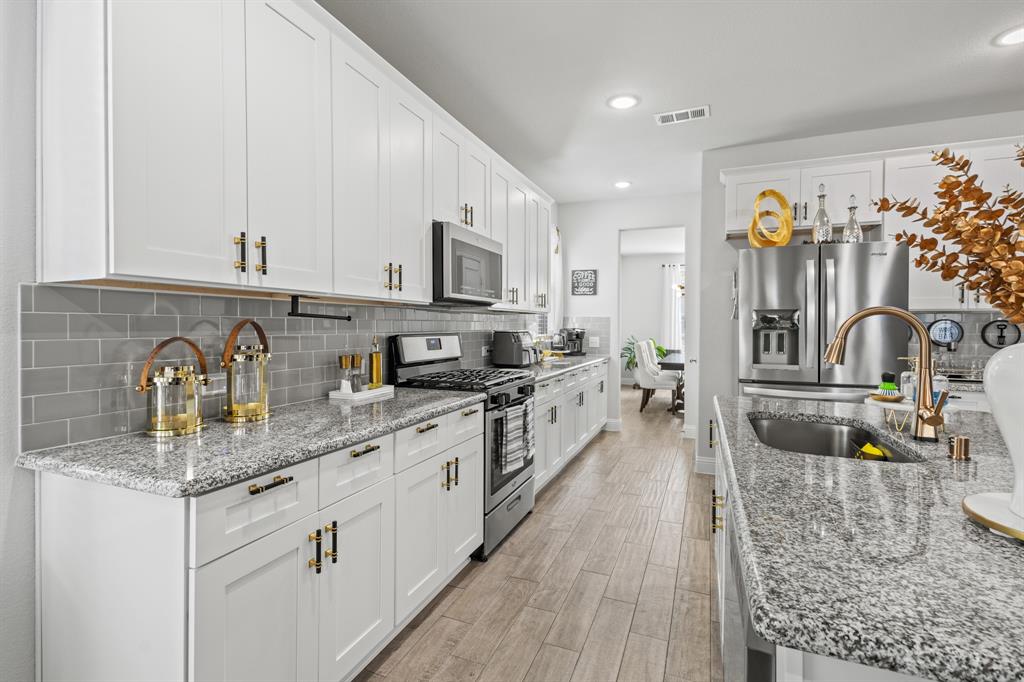 4220 Calla Drive Forney, TX 75126 - Photo 5 of 30 a kitchen with stainless steel appliances granite countertop a sink and cabinets