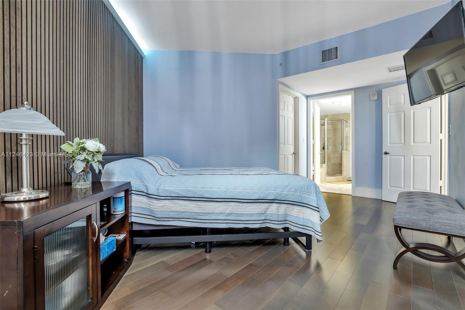 2030 Douglas Road, Unit 817 Coral Gables, FL 33134 - Photo 11 of 28 a bedroom with a bed and a table in it