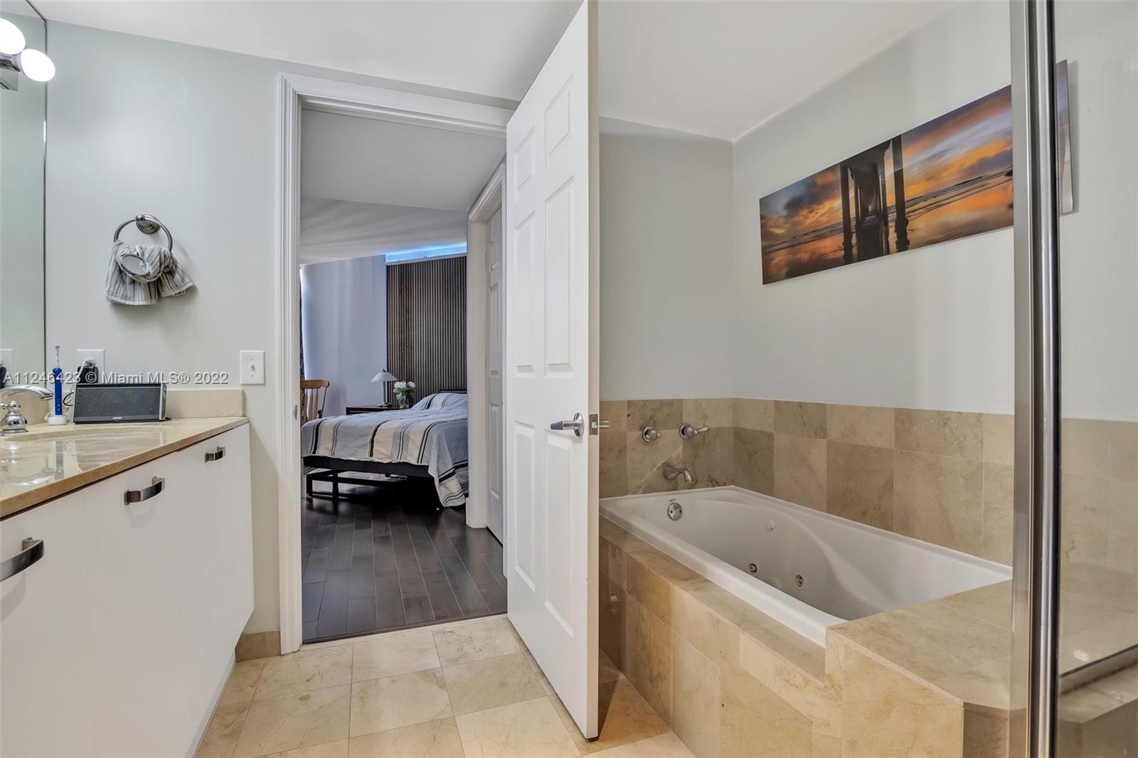 2030 Douglas Road, Unit 817 Coral Gables, FL 33134 - Photo 14 of 28 a en suite spacious bathroom with a tub double vanity and view bedroom