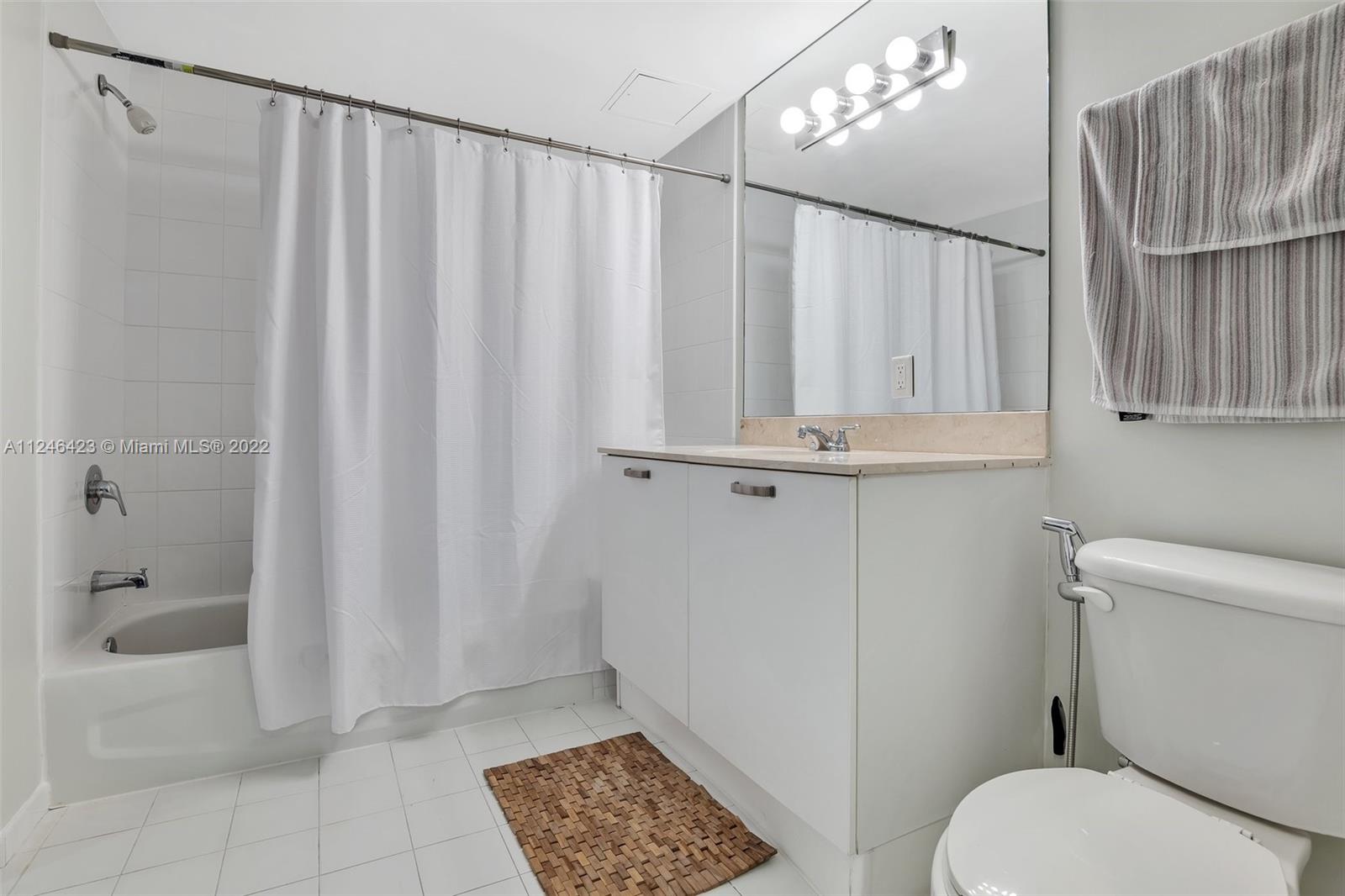 2030 Douglas Road, Unit 817 Coral Gables, FL 33134 - Photo 18 of 28 a bathroom with a shower curtain and a toilet