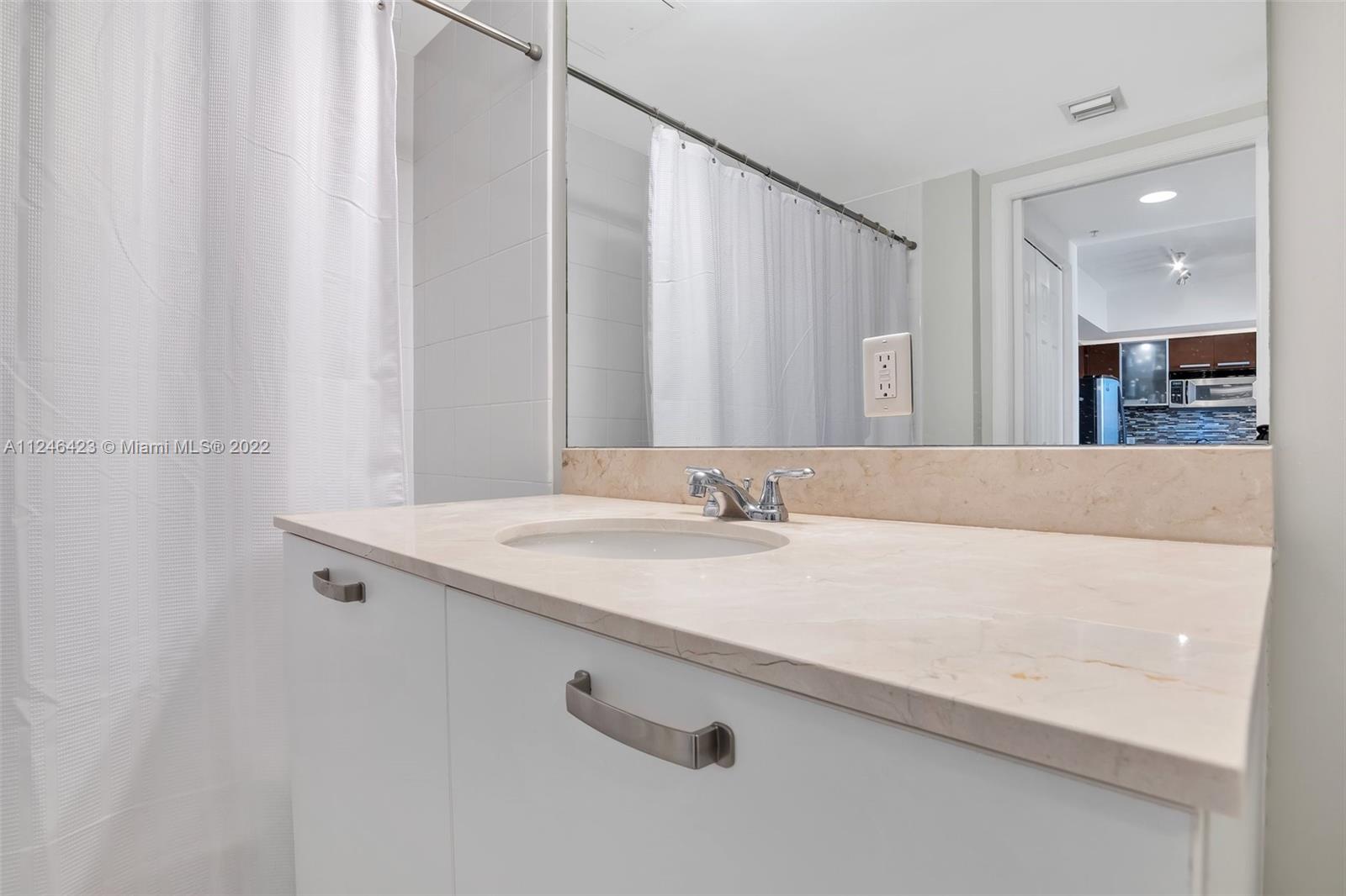 2030 Douglas Road, Unit 817 Coral Gables, FL 33134 - Photo 19 of 28 a bathroom with a granite countertop sink and a mirror