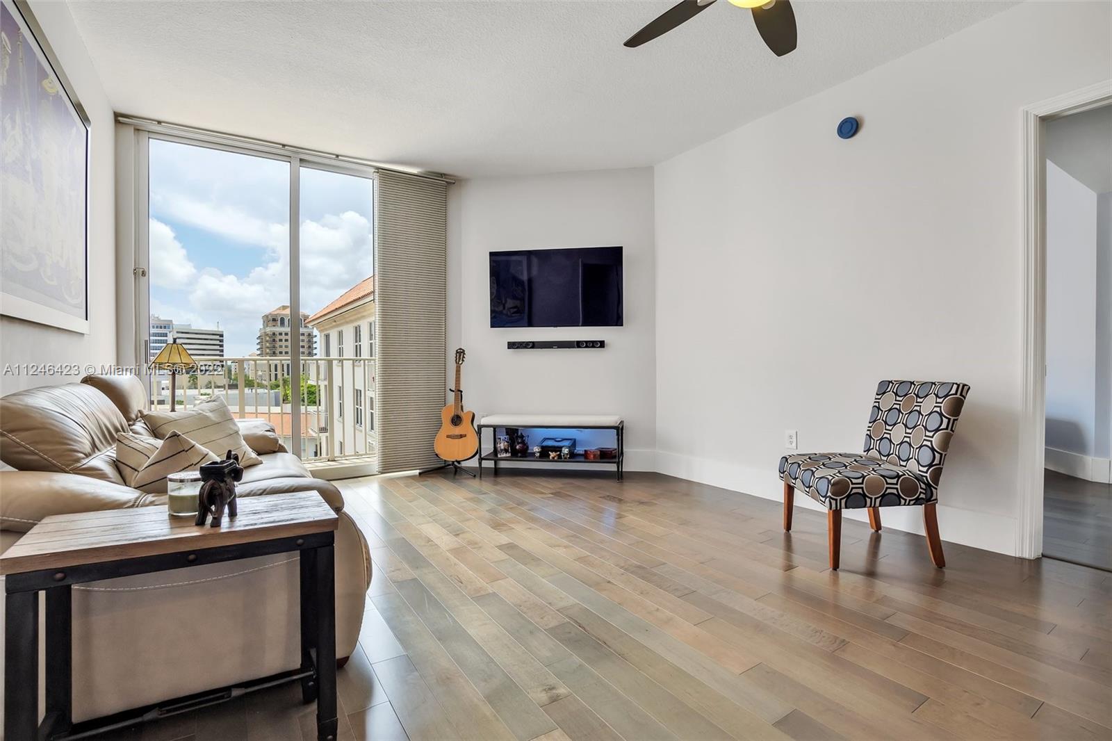 2030 Douglas Road, Unit 817 Coral Gables, FL 33134 - Photo 4 of 28 a living room with furniture and a flat screen tv